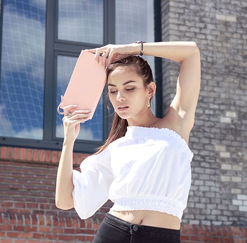 Hnědovlasá modelka s elegantním koženým dřevěným psaníčkem