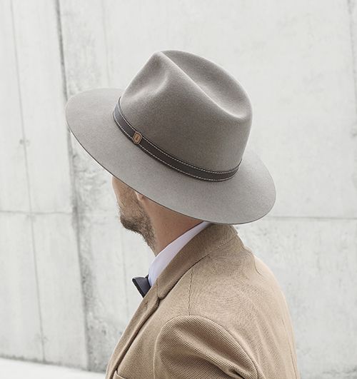 Muž v béžovém saku s elegantním kloboukem Apis hat a dřevěným motýlkem na krku