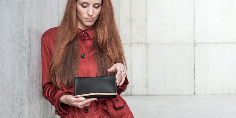 BeWooden - Žena se zrzavými vlasy v oranžovém kabátku drží koženou peněženku Api Woman Wallet