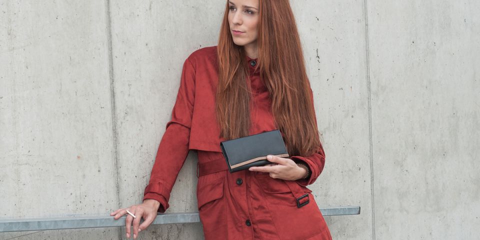 BeWooden - Žena se zrzavými vlasy v oranžovém kabátku drží koženou peněženku Caleo Woman Wallet