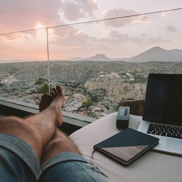 Muž sedí u okna a vedle sebe má zápisník Ocean Notebook