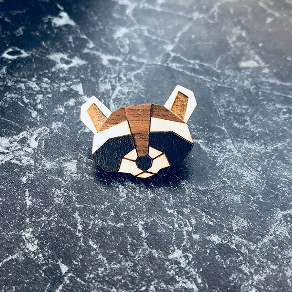 Dřevěná brož Raccoon Brooch na stole